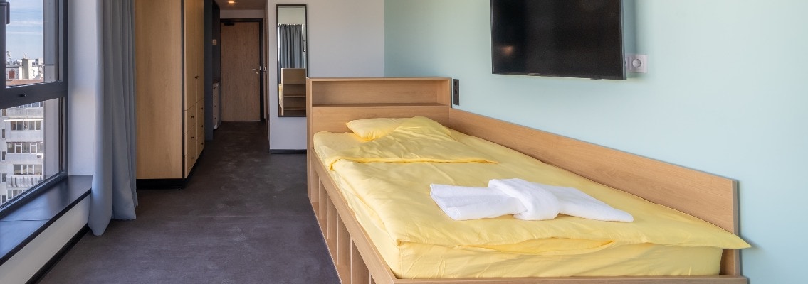 Simple student-style dorm bedroom. Hostel dormitory room. Campus